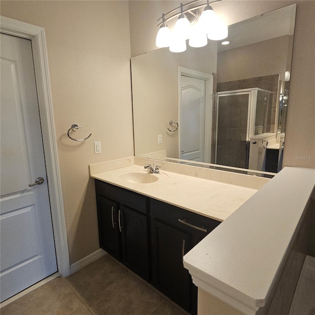 bathroom with vanity, a shower stall, tile patterned flooring, baseboards, and an inviting chandelier