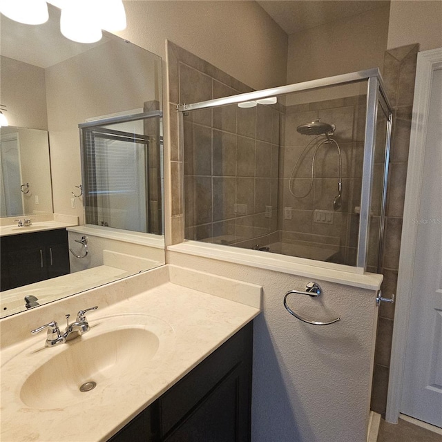 bathroom with vanity and tiled shower