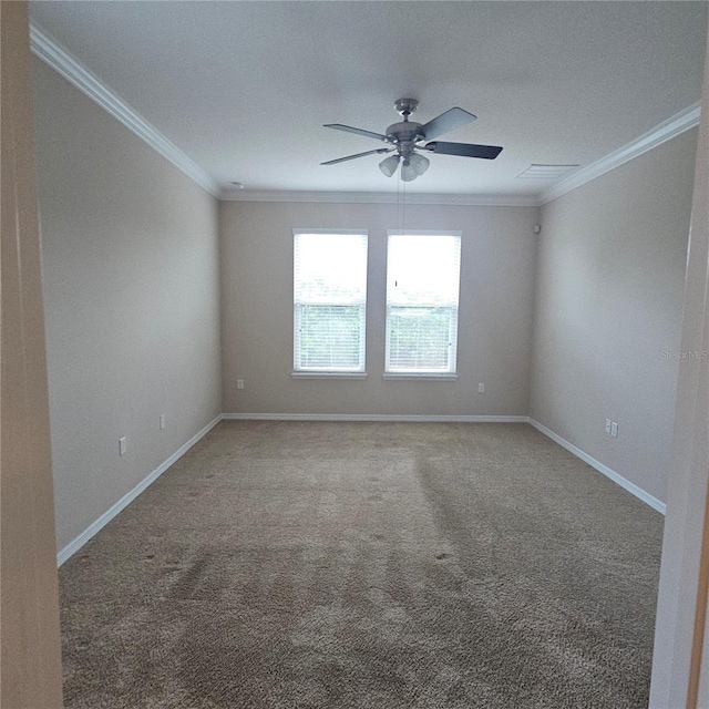 carpeted spare room featuring baseboards, visible vents, ceiling fan, and ornamental molding