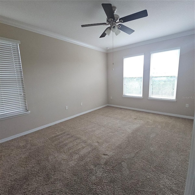 carpeted spare room with a ceiling fan, ornamental molding, and baseboards