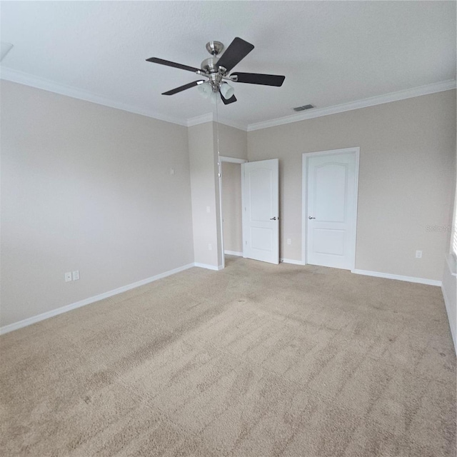 unfurnished bedroom with visible vents, carpet, baseboards, ornamental molding, and ceiling fan