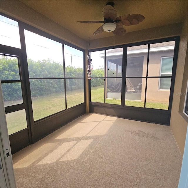 unfurnished sunroom with ceiling fan