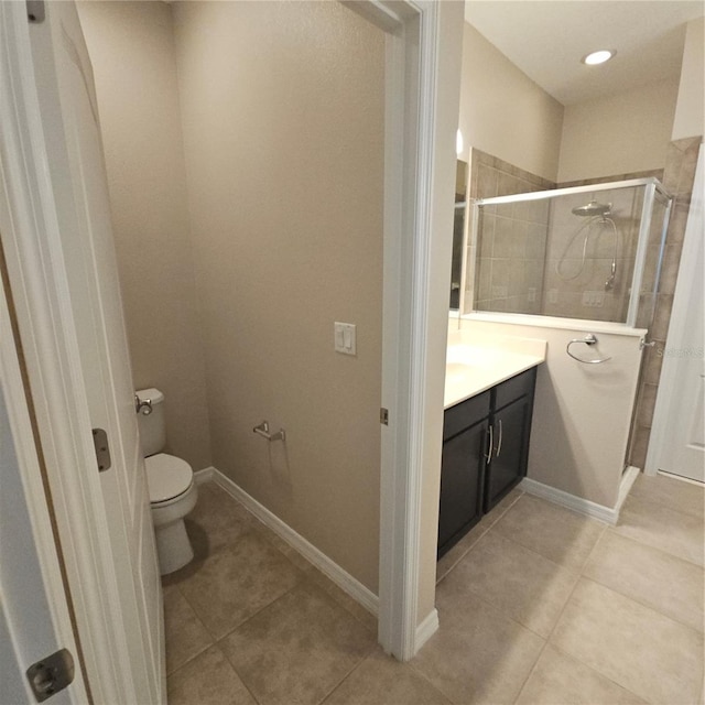 full bathroom featuring toilet, vanity, a stall shower, and tile patterned flooring