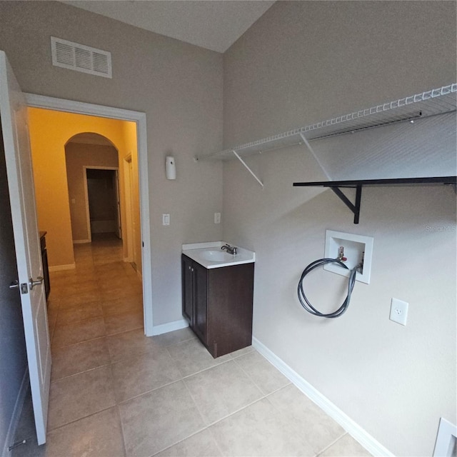 laundry area featuring visible vents, washer hookup, laundry area, arched walkways, and light tile patterned floors