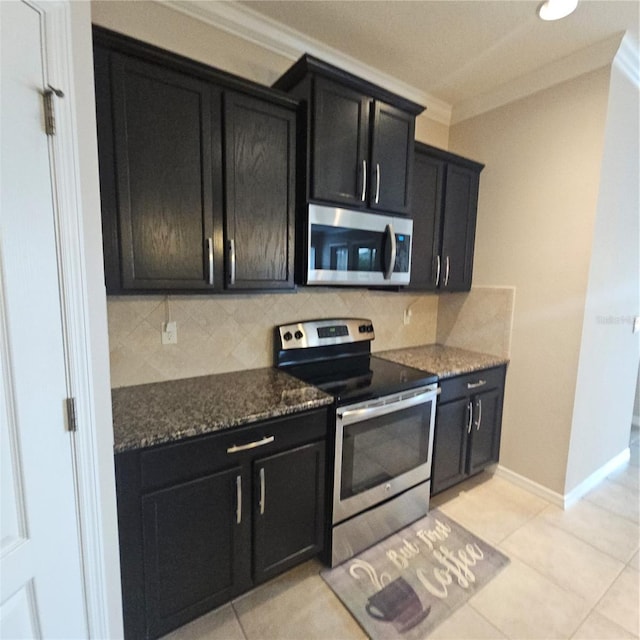 kitchen with ornamental molding, dark cabinets, appliances with stainless steel finishes, and tasteful backsplash