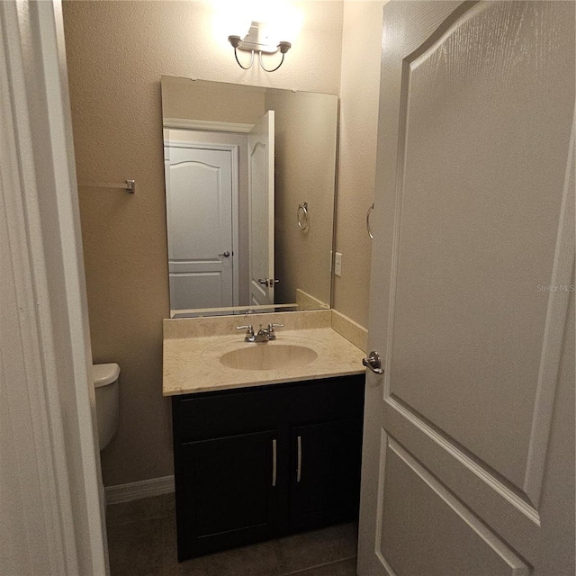 half bathroom with toilet, vanity, and baseboards