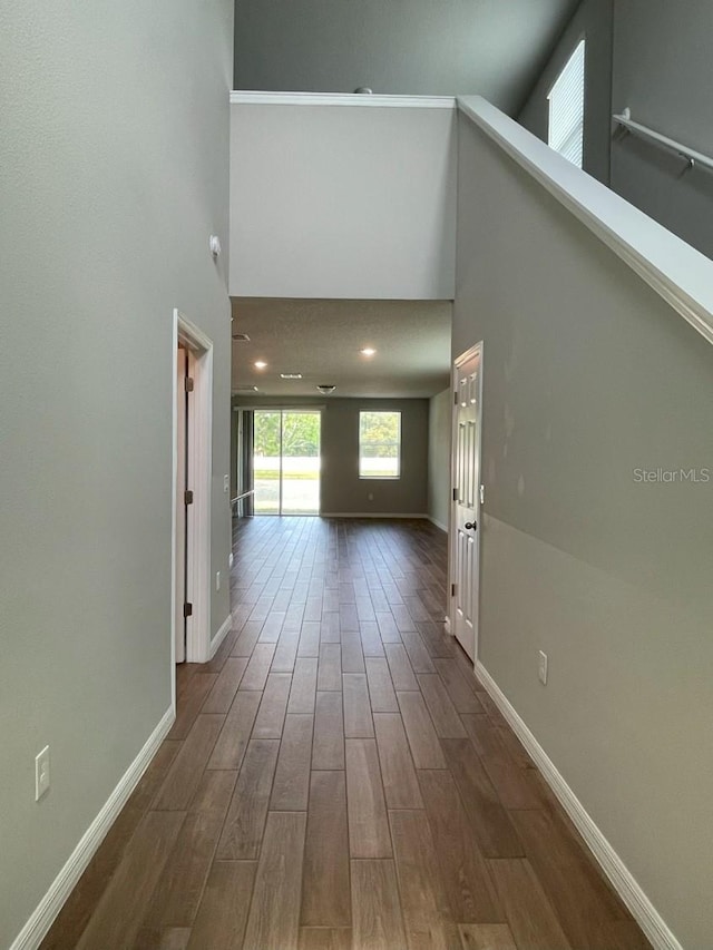 5273 Sanders Oak Trl, Saint Cloud, FL 34771 - hallway with dark wood-type flooring, a high ceiling, and baseboards
