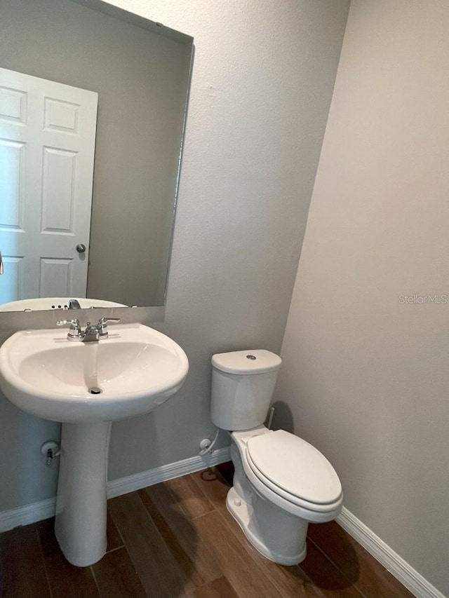 5273 Sanders Oak Trl, Saint Cloud, FL 34771 - bathroom featuring toilet, baseboards, and wood finish floors