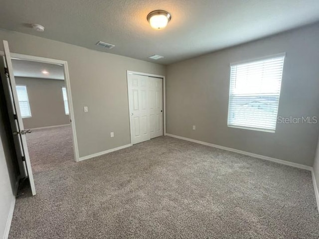 5273 Sanders Oak Trl, Saint Cloud, FL 34771 - unfurnished bedroom featuring carpet, visible vents, multiple windows, and baseboards