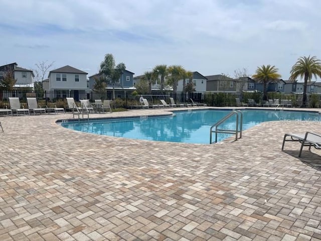 5273 Sanders Oak Trl, Saint Cloud, FL 34771 - community pool featuring a patio area, a residential view, and fence