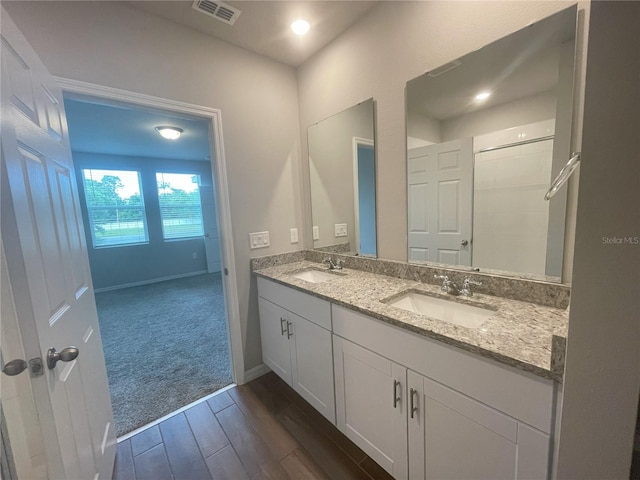 5273 Sanders Oak Trl, Saint Cloud, FL 34771 - full bath featuring a sink, visible vents, double vanity, and wood finished floors
