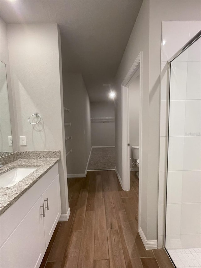 5273 Sanders Oak Trl, Saint Cloud, FL 34771 - full bathroom with a spacious closet, toilet, vanity, wood finished floors, and a stall shower