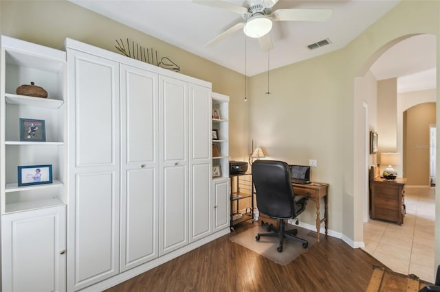 155 Cape Florida Dr, Poinciana, FL 34759 - home office featuring a ceiling fan, wood finished floors, baseboards, visible vents, and arched walkways