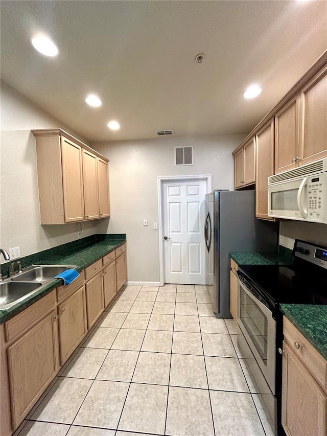 3351 Whitestone Cir Unit 101, Kissimmee, FL 34741 - kitchen with dark countertops, a sink, stainless steel range with electric stovetop, white microwave, and visible vents