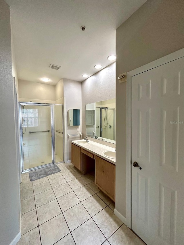 3351 Whitestone Cir Unit 101, Kissimmee, FL 34741 - bathroom with double vanity, tile patterned floors, visible vents, and a shower stall