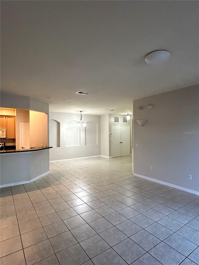 3351 Whitestone Cir Unit 101, Kissimmee, FL 34741 - unfurnished living room with baseboards, a chandelier, light tile patterned flooring, and visible vents