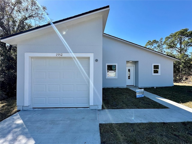 single story home featuring stucco siding and concrete driveway