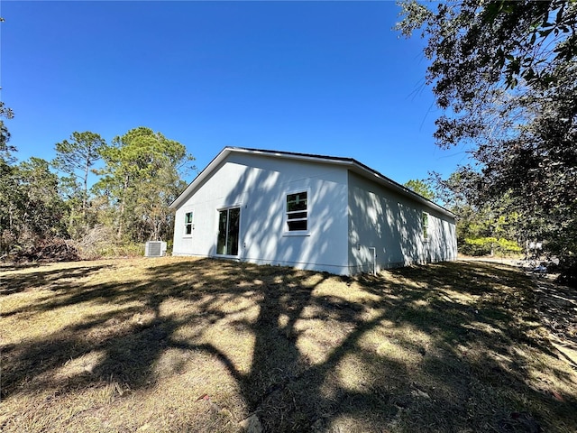 view of side of home with central AC