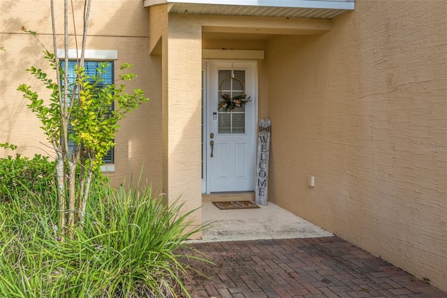 view of exterior entry featuring stucco siding