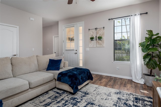 living room with baseboards, wood finished floors, and a ceiling fan
