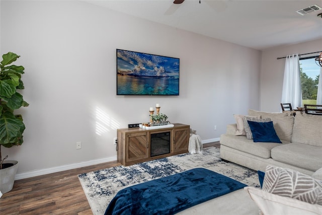 living area with baseboards, visible vents, wood finished floors, and a ceiling fan