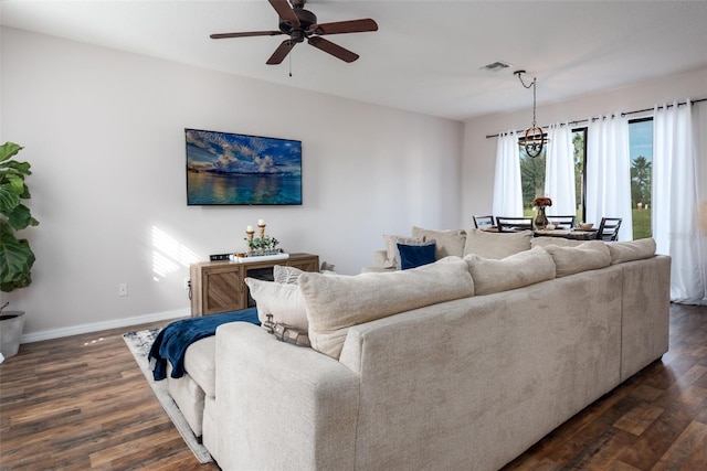 living room featuring baseboards, visible vents, ceiling fan, and dark wood-type flooring