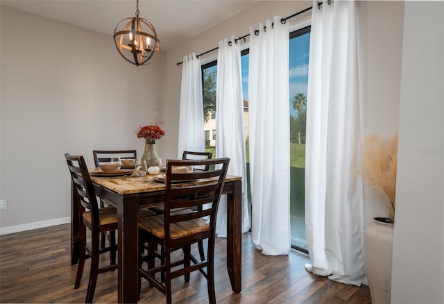 dining space featuring baseboards, dark wood-style flooring, and an inviting chandelier