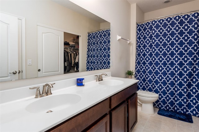 bathroom featuring toilet, a sink, and double vanity