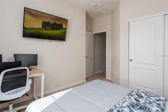 carpeted bedroom featuring baseboards and a closet