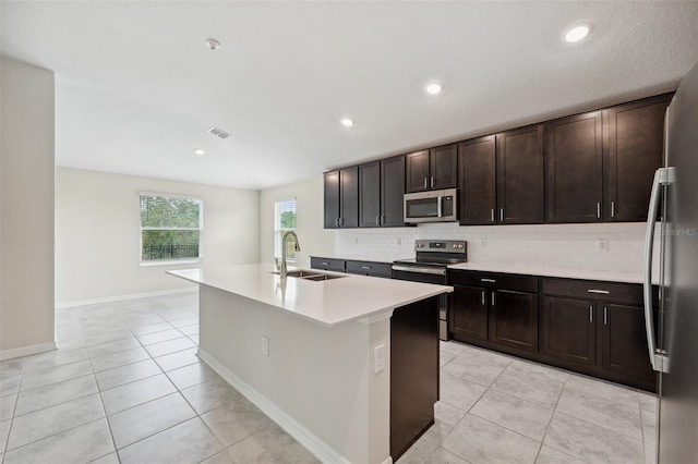 1848 Ancestry Trl, Kissimmee, FL 34746 - kitchen with appliances with stainless steel finishes, tasteful backsplash, light tile patterned flooring, an island with sink, and recessed lighting