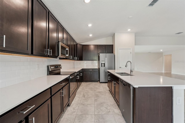 1848 Ancestry Trl, Kissimmee, FL 34746 - kitchen featuring stainless steel appliances, tasteful backsplash, light countertops, a kitchen island with sink, and dark brown cabinetry