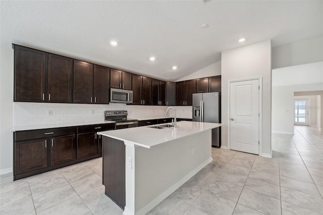 1848 Ancestry Trl, Kissimmee, FL 34746 - kitchen featuring stainless steel appliances, vaulted ceiling, backsplash, light countertops, and a kitchen island with sink