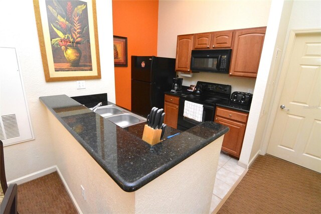 8100 Poinciana Blvd Unit 2111, Orlando, FL 32821 - kitchen with light tile patterned floors, dark stone countertops, a sink, a peninsula, and black appliances