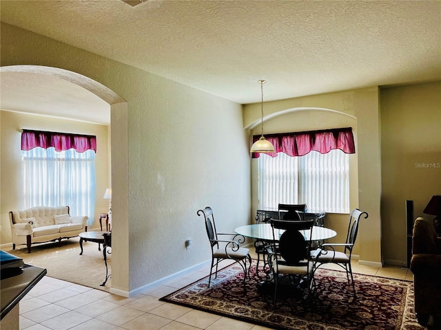 2920 River Birch Dr, Kissimmee, FL 34741 - dining space featuring arched walkways, a textured ceiling, a healthy amount of sunlight, and tile patterned flooring