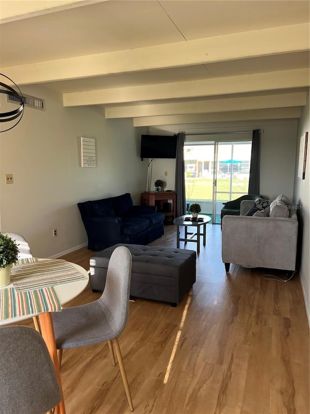 living room featuring wood finished floors, baseboards, and beam ceiling