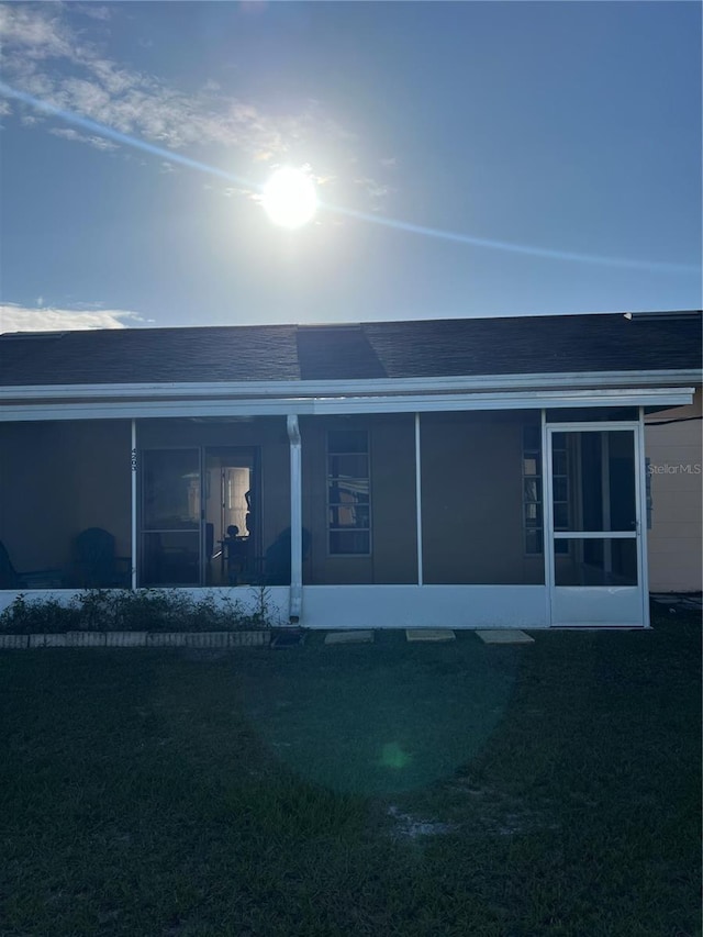 rear view of house featuring a sunroom
