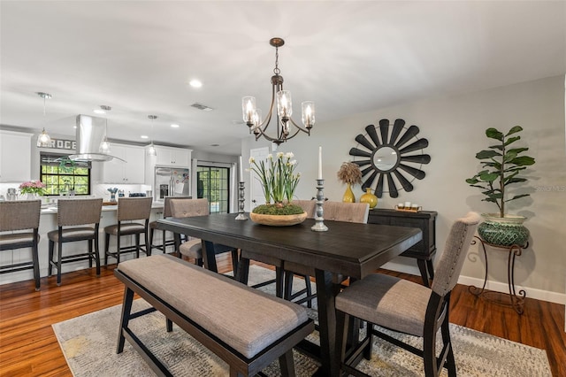 1999 Sir Lancelot Cir, Saint Cloud, FL 34772 - dining area featuring wood finished floors, an inviting chandelier, baseboards, visible vents, and recessed lighting
