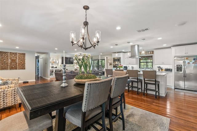 1999 Sir Lancelot Cir, Saint Cloud, FL 34772 - dining space with wood finished floors, visible vents, a wealth of natural light, and a notable chandelier