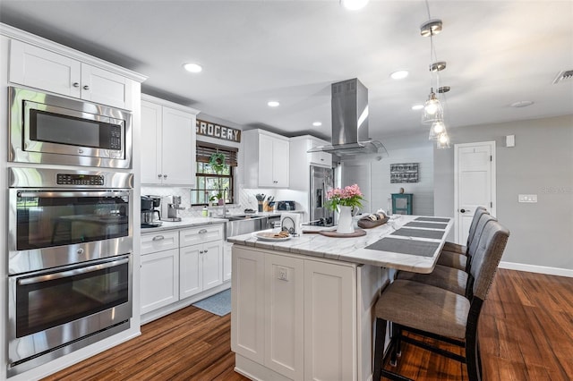 1999 Sir Lancelot Cir, Saint Cloud, FL 34772 - kitchen with island exhaust hood, a sink, dark wood finished floors, an island with sink, and appliances with stainless steel finishes