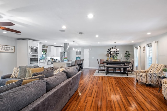 1999 Sir Lancelot Cir, Saint Cloud, FL 34772 - living area with dark wood-style flooring, baseboards, visible vents, recessed lighting, and ceiling fan with notable chandelier