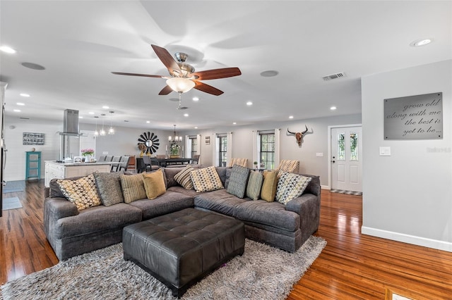 1999 Sir Lancelot Cir, Saint Cloud, FL 34772 - living area featuring recessed lighting, wood finished floors, visible vents, baseboards, and ceiling fan with notable chandelier