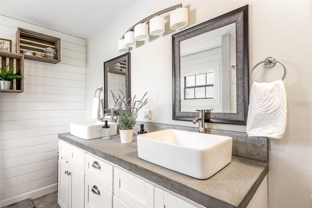 1999 Sir Lancelot Cir, Saint Cloud, FL 34772 - bathroom featuring visible vents, wood walls, a sink, and double vanity