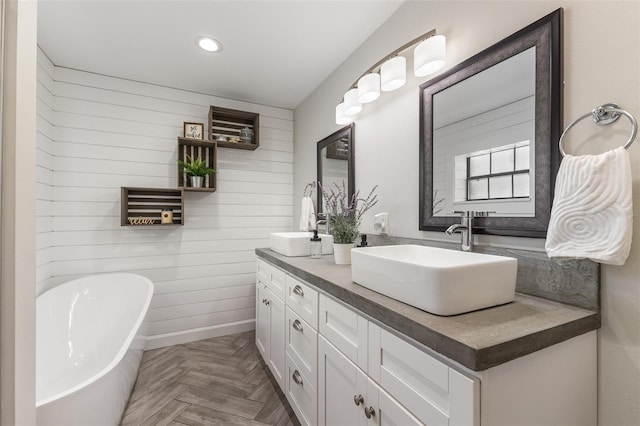 1999 Sir Lancelot Cir, Saint Cloud, FL 34772 - full bathroom featuring a sink, double vanity, a freestanding bath, wood walls, and recessed lighting