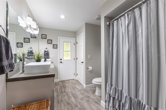 1999 Sir Lancelot Cir, Saint Cloud, FL 34772 - bathroom with toilet, visible vents, baseboards, wood finished floors, and vanity