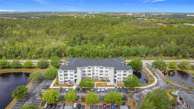 drone / aerial view with a forest view and a water view