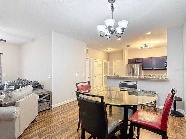 dining room featuring recessed lighting, baseboards, dark wood-style floors, and an inviting chandelier