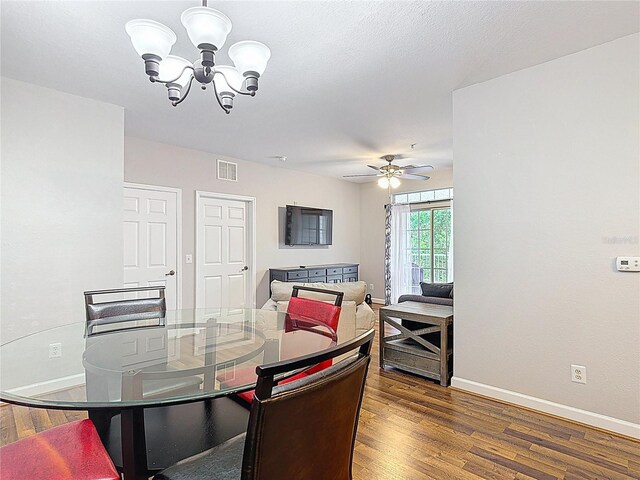 dining room with visible vents, baseboards, dark wood-style flooring, and ceiling fan with notable chandelier