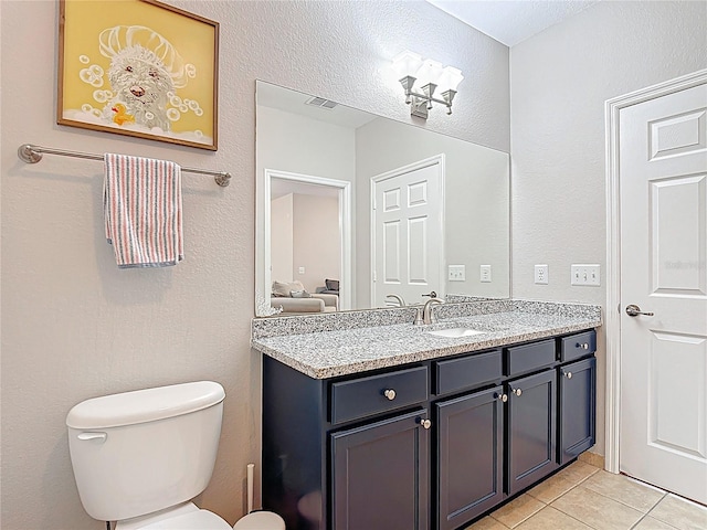 bathroom with visible vents, tile patterned flooring, vanity, and toilet