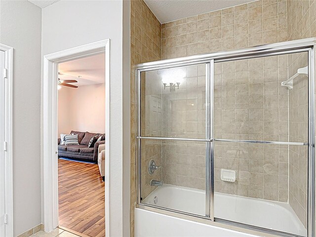 bathroom with tile patterned floors, a ceiling fan, and enclosed tub / shower combo