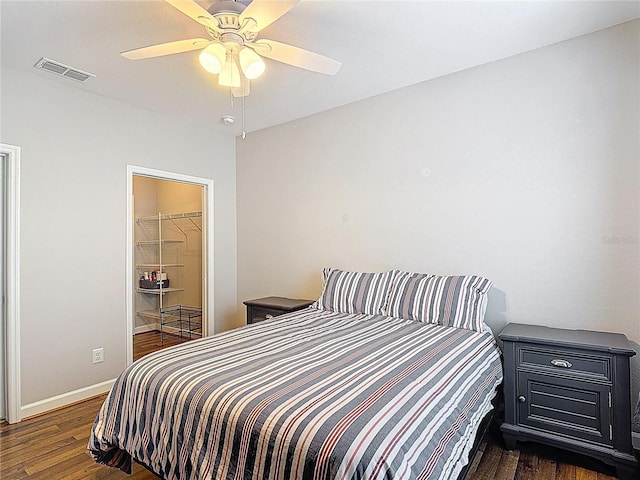 bedroom featuring wood finished floors, visible vents, baseboards, and ceiling fan
